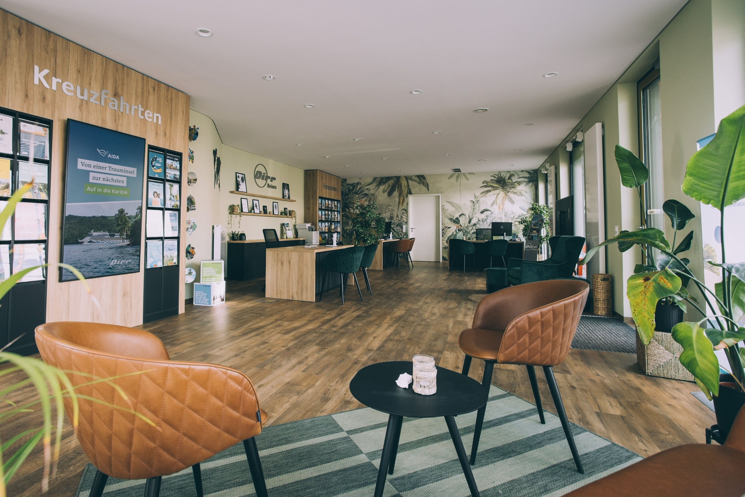 Blick in ein modernes Reisebüro mit gemütlichen Sitzecken und Reisekatalogen